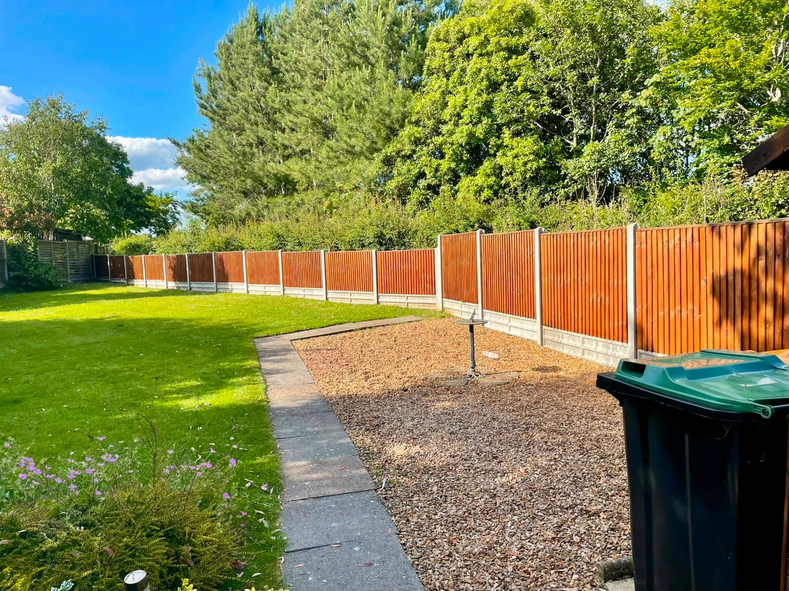 The same run of panels evenly coated in a rich red-brown stain along its whole length