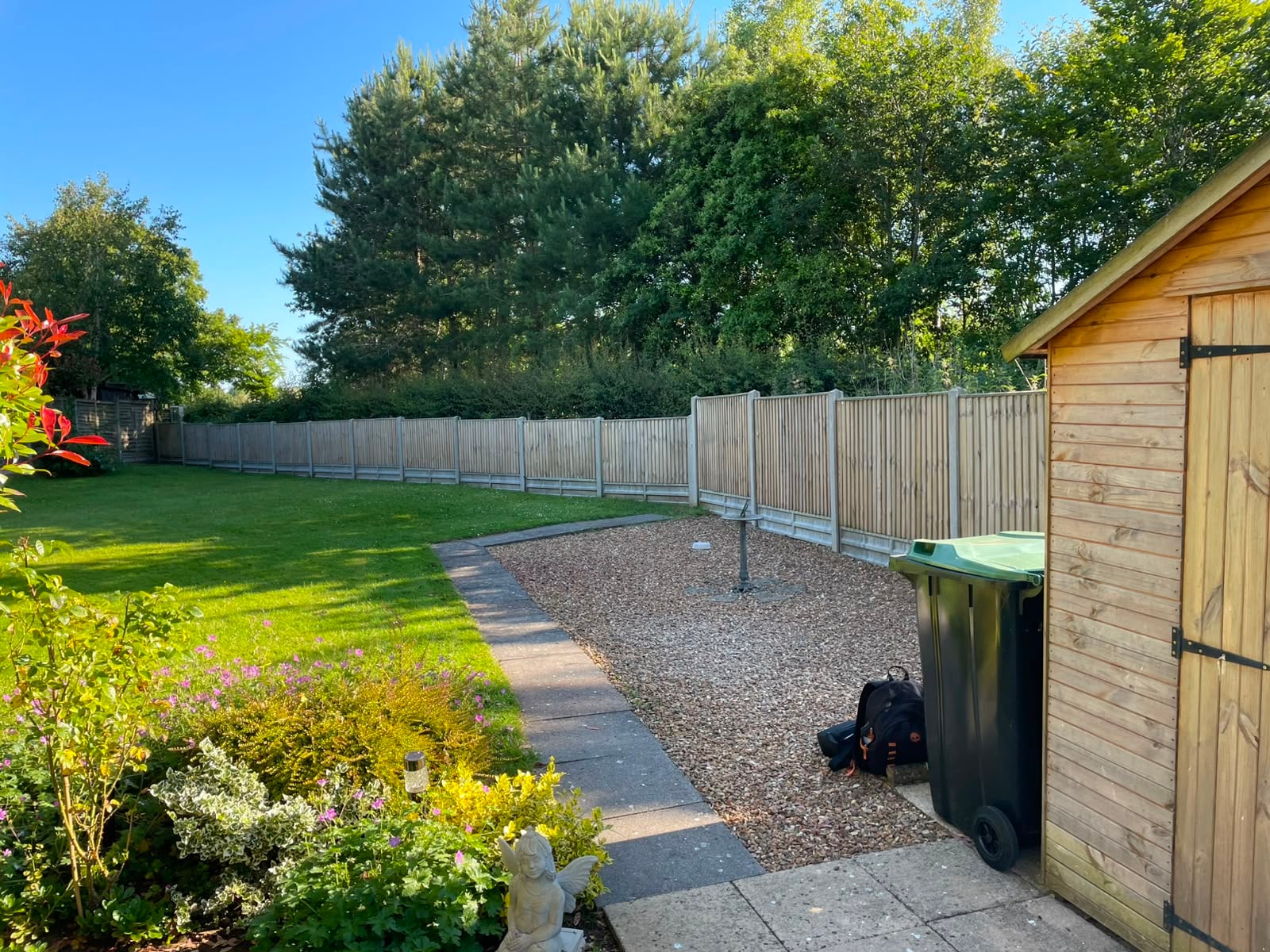 A long run of closeboard fence panels weathered back to bare silver-grey timber