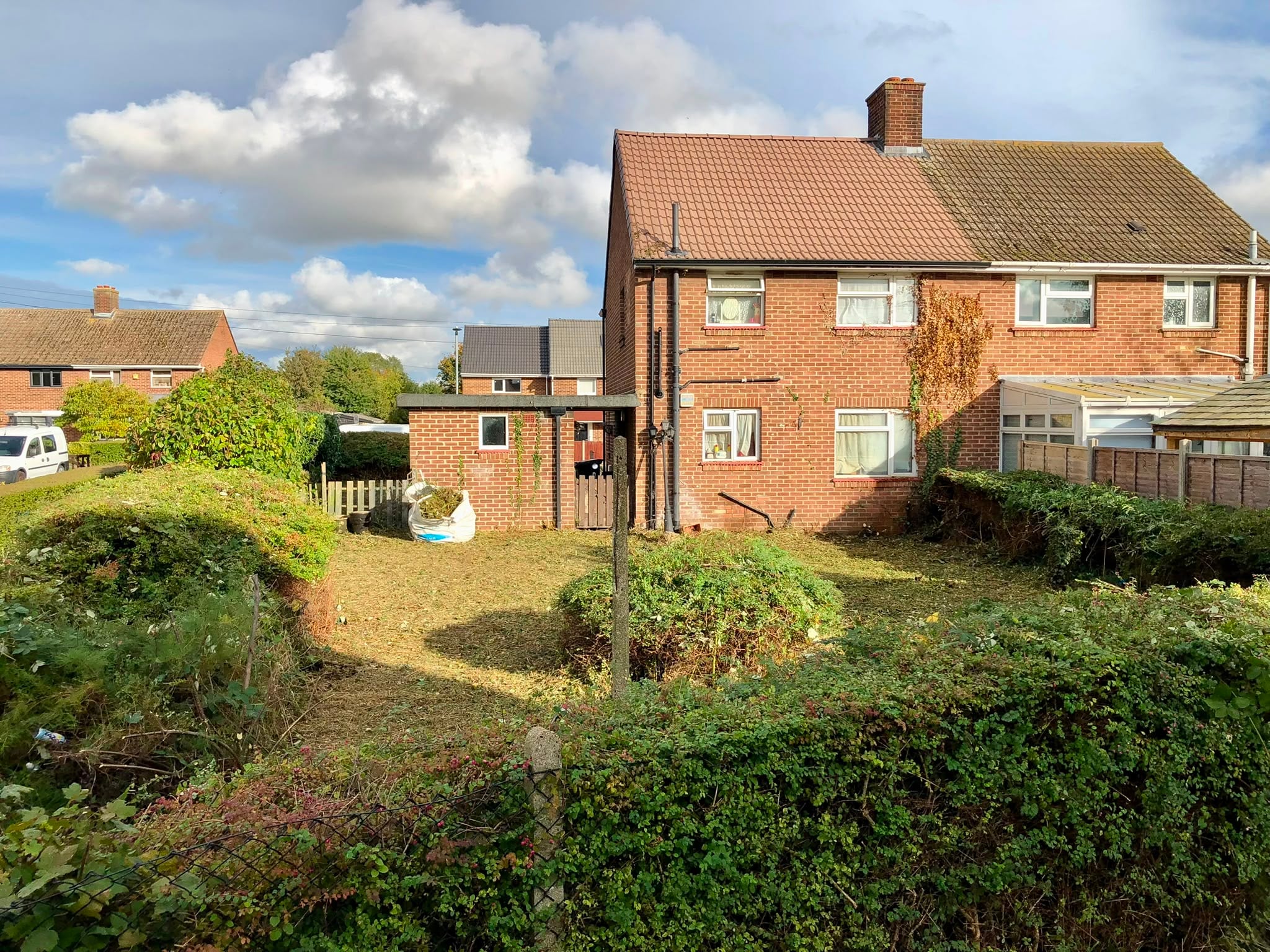 The same garden cut right back to ground level, the growth bagged and the house and outbuilding clear again